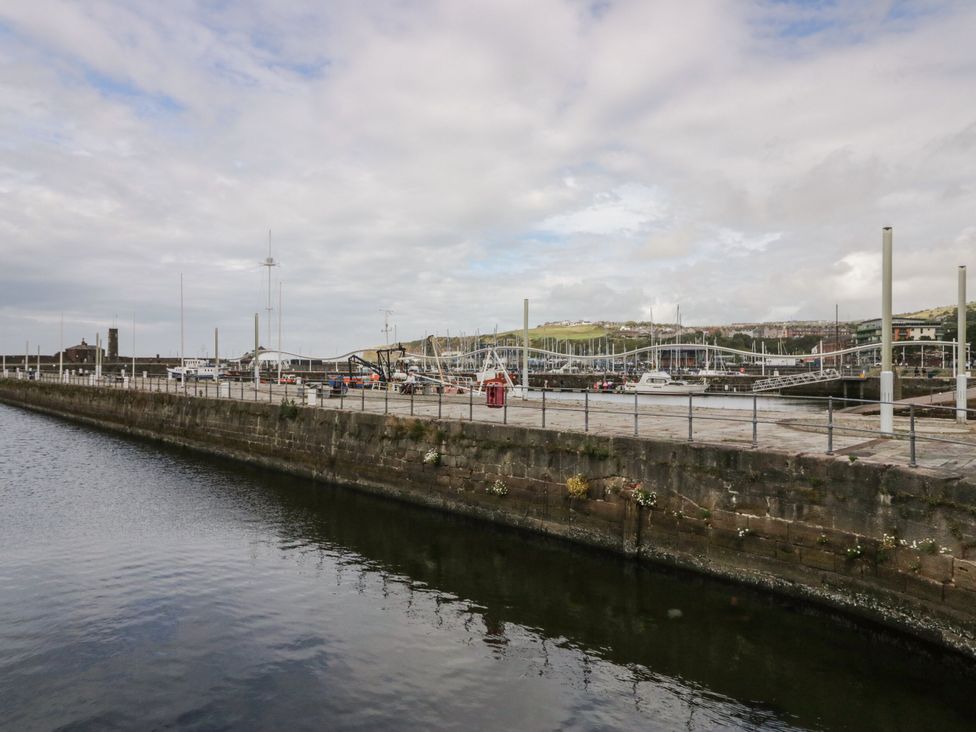 A harbor with boats and a dock at Lowther Suite in Whitehaven