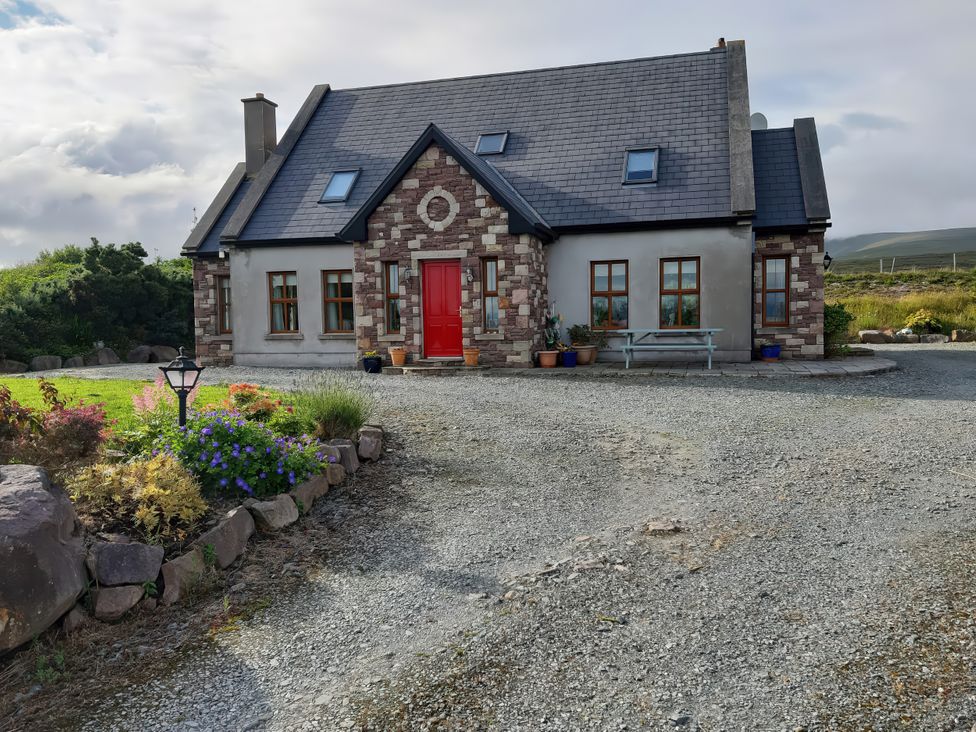 A house with a red door and flower beds at Moynish Mor Mulranny MULRANNY