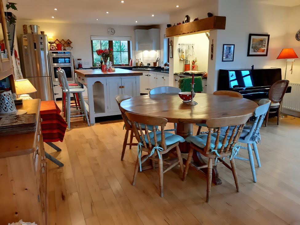 A kitchen with a dining table and piano at Moynish Mor Mulranny in MULRANNY
