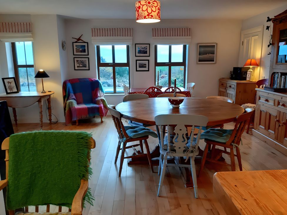 A dining room with a round table and chairs at Moynish Mor Mulranny in MULRANNY