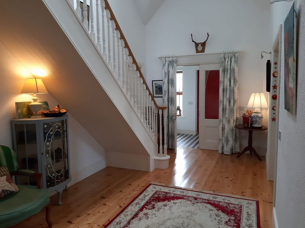 A hallway with a staircase and decorative items at Moynish Mor Mulranny in MULRANNY