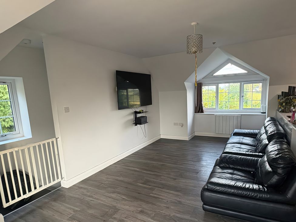 A living room with a sofa and television at Skerry Vore in Llandudno Junction