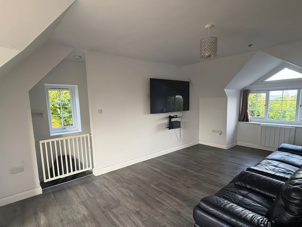A living room with a sofa and a television at Skerry Vore in Llandudno Junction