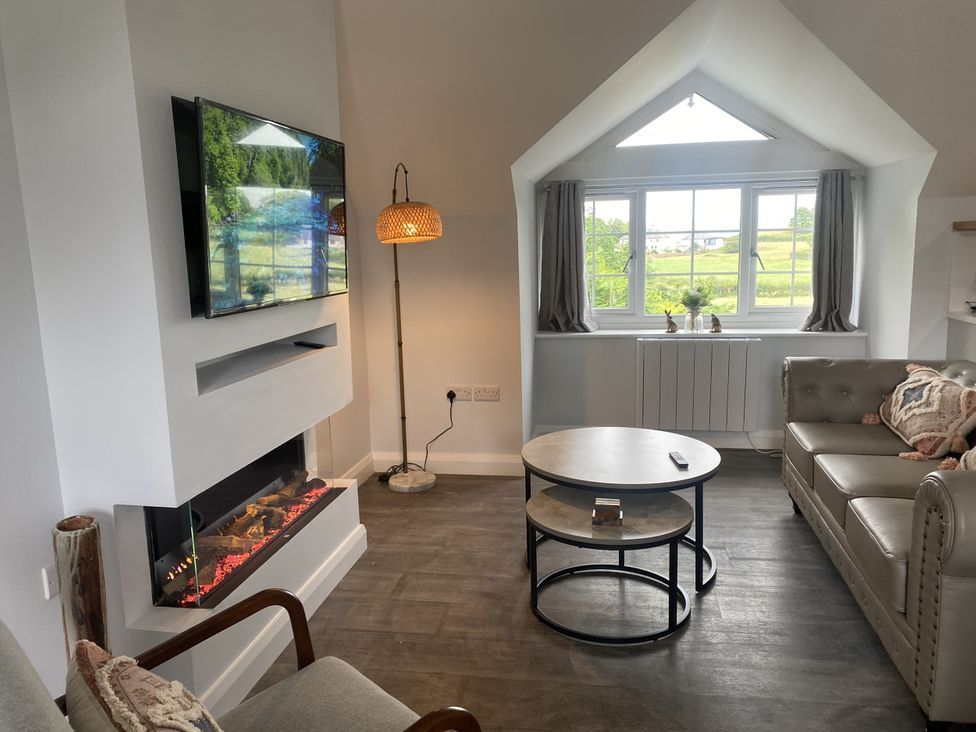 A living room with a television and sofa at The Gatekeepers Cottage - Skerry Vore Bryn Pydew near Llandudno Junction
