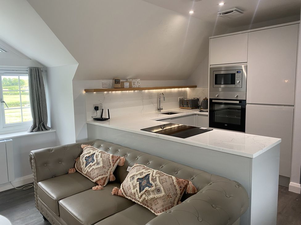 A kitchen with a countertop and modern appliances at The Gatekeepers Cottage - Skerry Vore, Bryn Pydew near Llandudno Junction