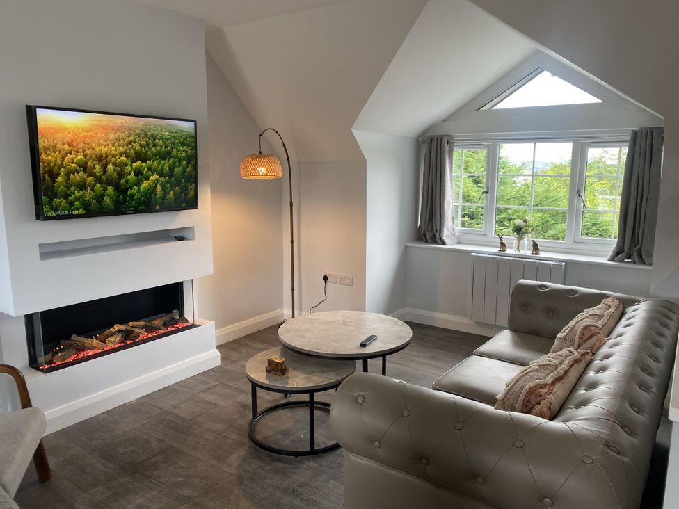 A living room with a sofa and television at The Gatekeepers Cottage - Skerry Vore near Bryn Pydew Llandudno Junction