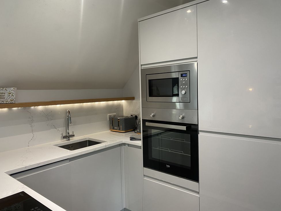 A kitchen with microwave and sink at The Gatekeepers Cottage - Skerry Vore near Bryn Pydew
