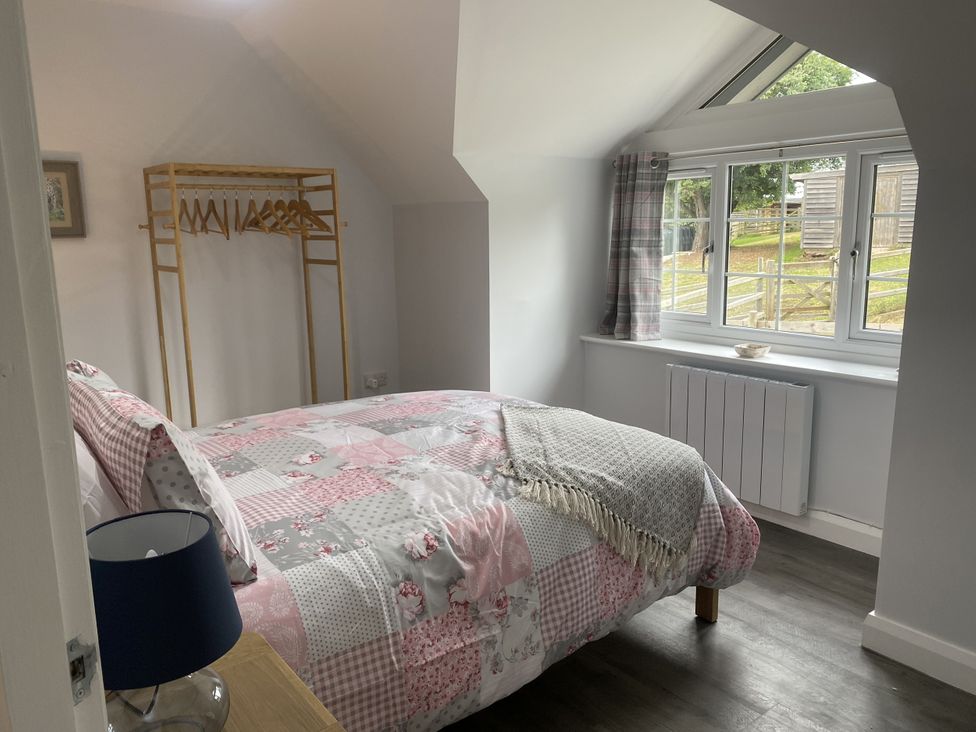 A bedroom with a bed and wardrobe at The Gatekeepers Cottage - Skerry Vore in Bryn Pydew near Llandudno Junction