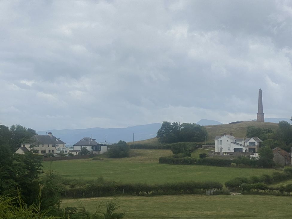 A view of houses and a monument on a hill at The Gatekeepers Cottage - Skerry Vore Bryn Pydew near Llandudno Junction