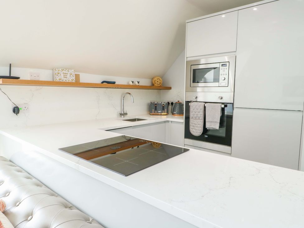 A kitchen with countertop, sink, and appliances at The Gatekeepers Cottage - Skerry Vore, Bryn Pydew near Llandudno Junction