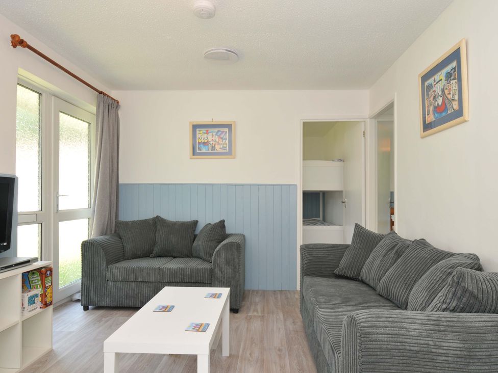 A living room with a sofa and coffee table at 4 Rosecraddoc Lodge Holiday Bungalows in Liskeard