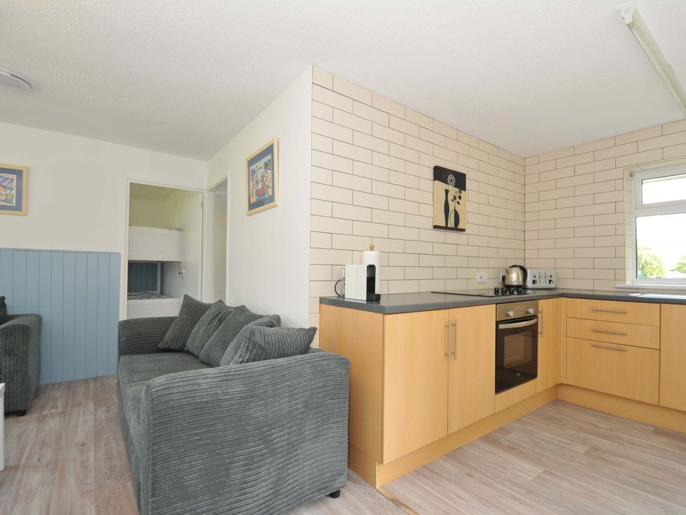 A living room with a sofa and kitchen unit at 4 Rosecraddoc Lodge Holiday Bungalows Liskeard