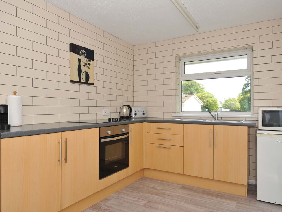 A kitchen with countertops, oven, and window at 4 Rosecraddoc Lodge Holiday Bungalows in Liskeard