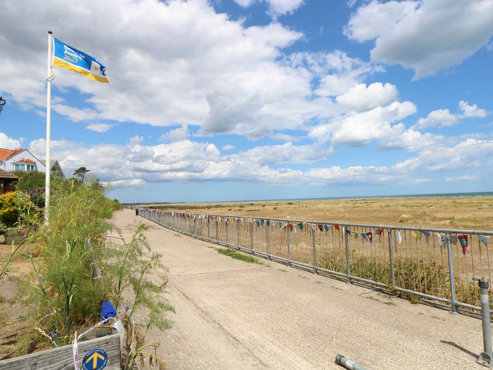 A pathway along the sea with a flag and fence at No. 2 - Seaview Kessingland