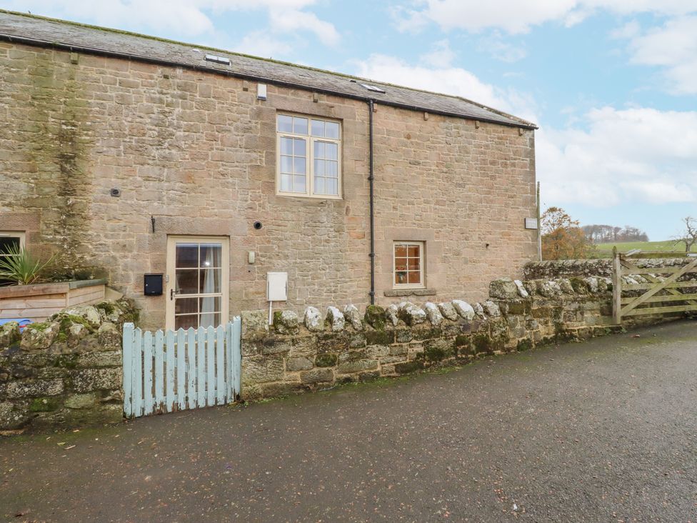 A stone building with windows and a door at Watermill Cottage in North Charlton