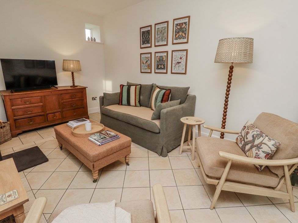 A living room with furniture and decor at Watermill Cottage in North Charlton