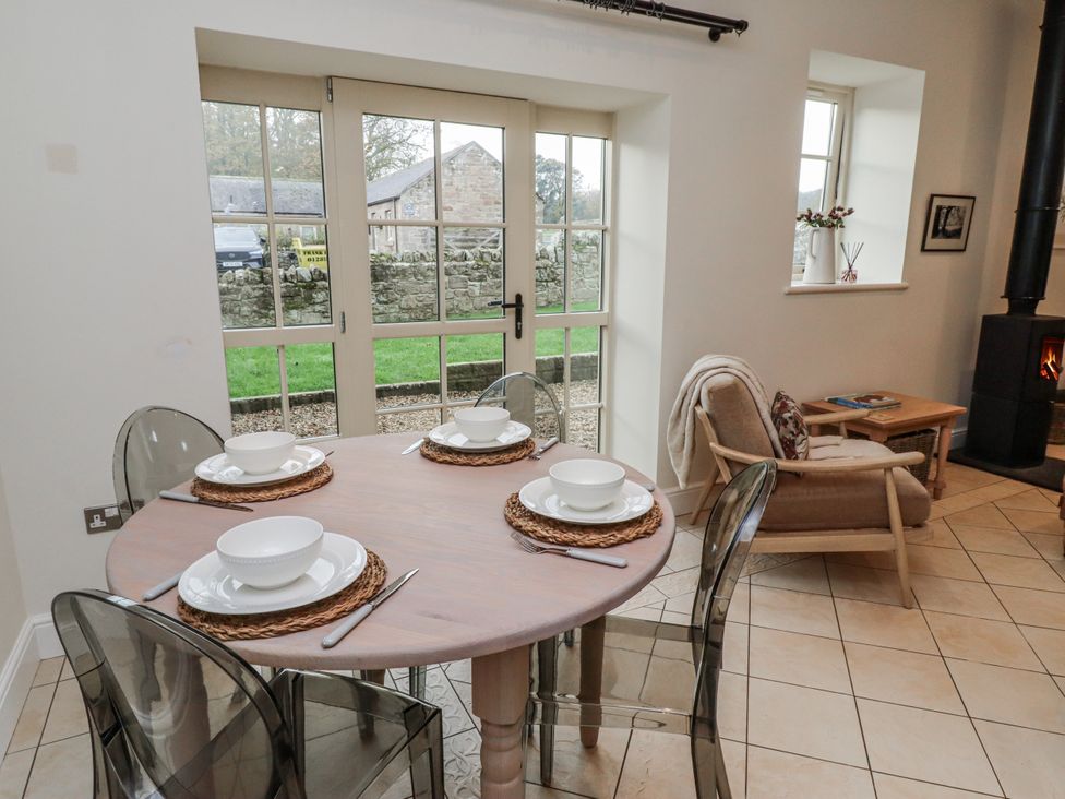 A dining area with a table set for four at Watermill Cottage in North Charlton