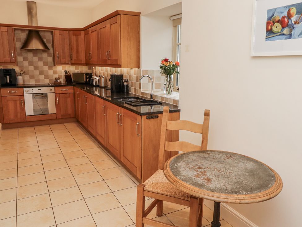 A kitchen with cabinets and appliances at Watermill Cottage in North Charlton