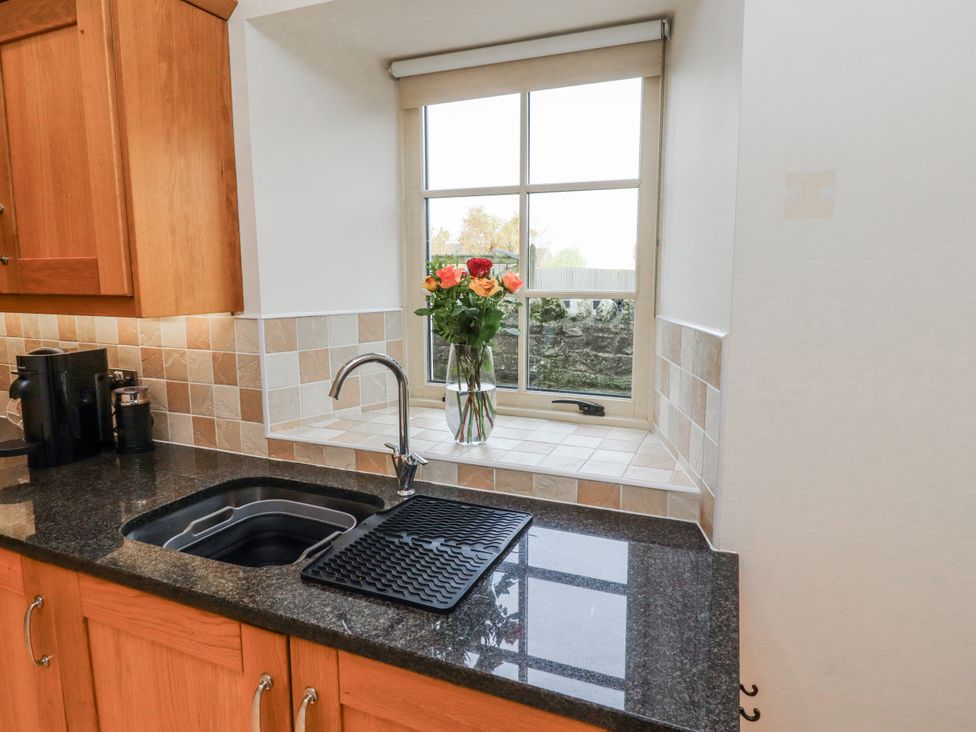 A kitchen with a sink and a window at Watermill Cottage in North Charlton