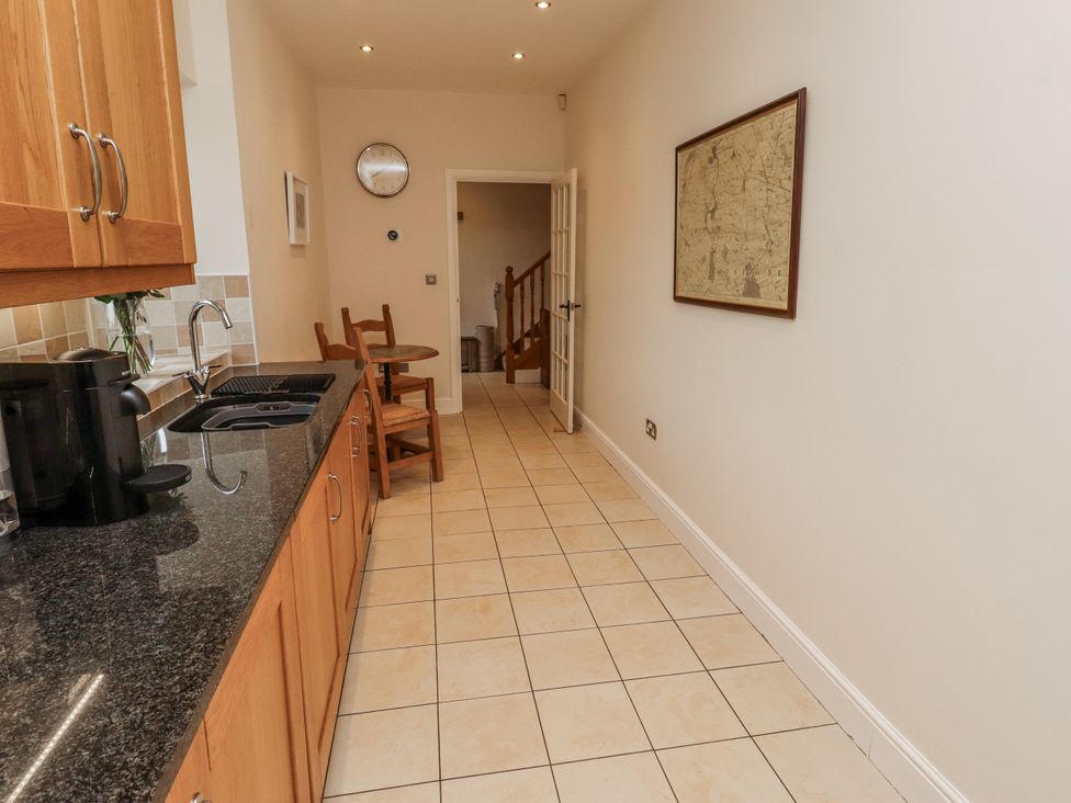 A kitchen with a countertop and dining table at Watermill Cottage in North Charlton