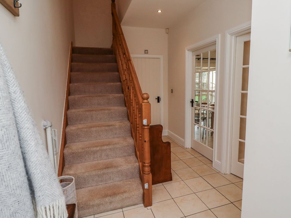 A hallway with stairs and doors at Watermill Cottage in North Charlton