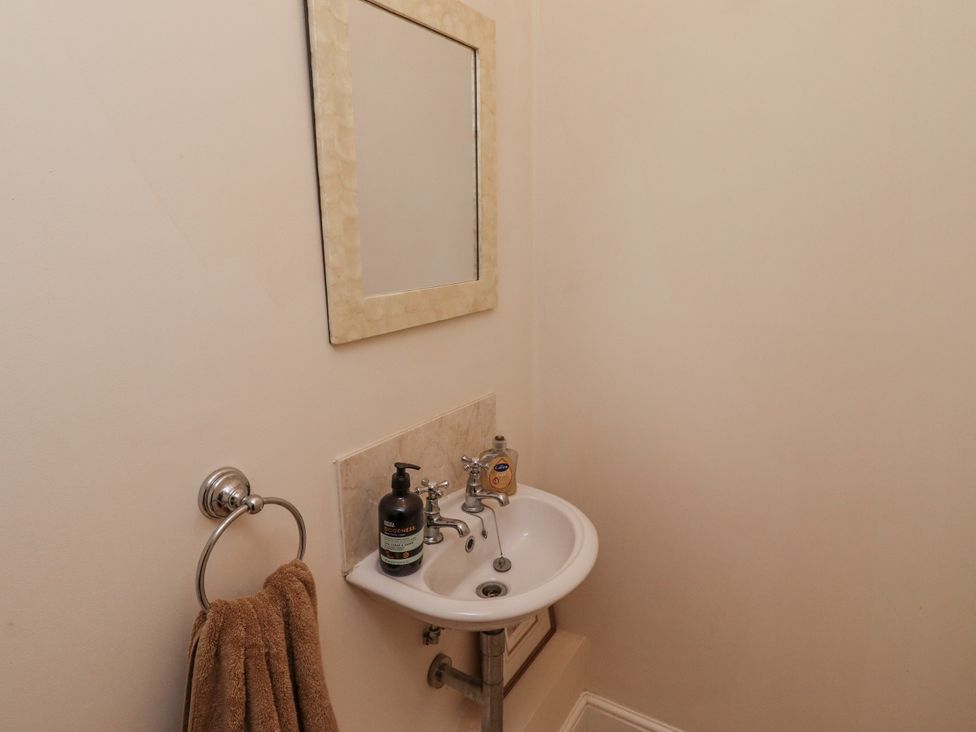 A bathroom with a sink and mirror at Watermill Cottage in North Charlton