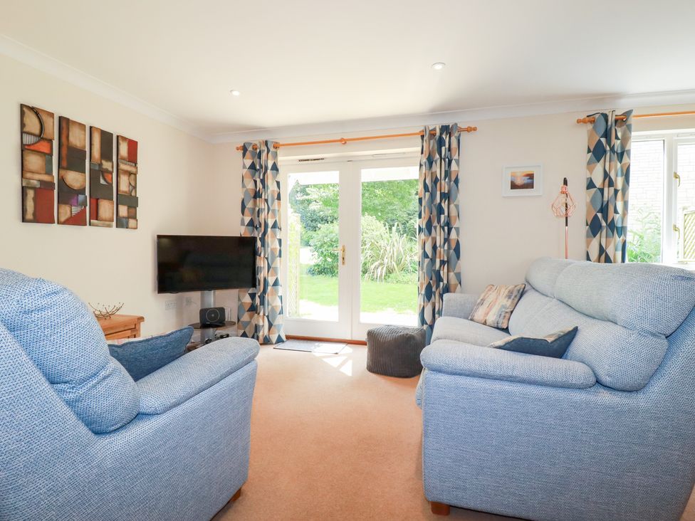 A living room with two sofas and a television at Trouts Reach in Falmouth