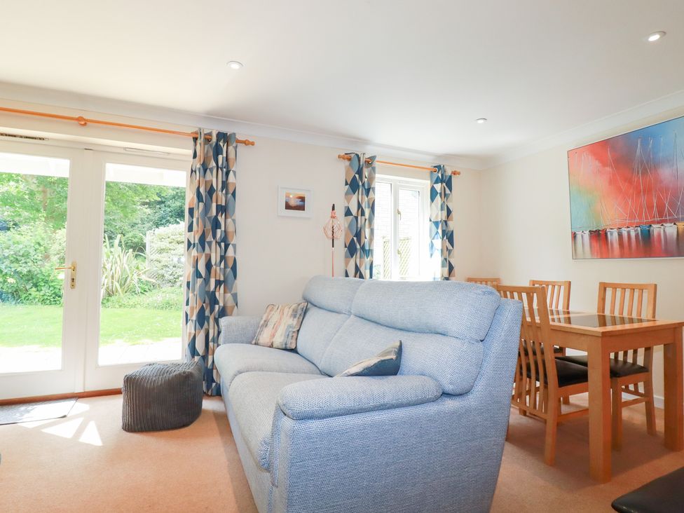 A living room with a sofa and dining table at Trouts Reach in Falmouth