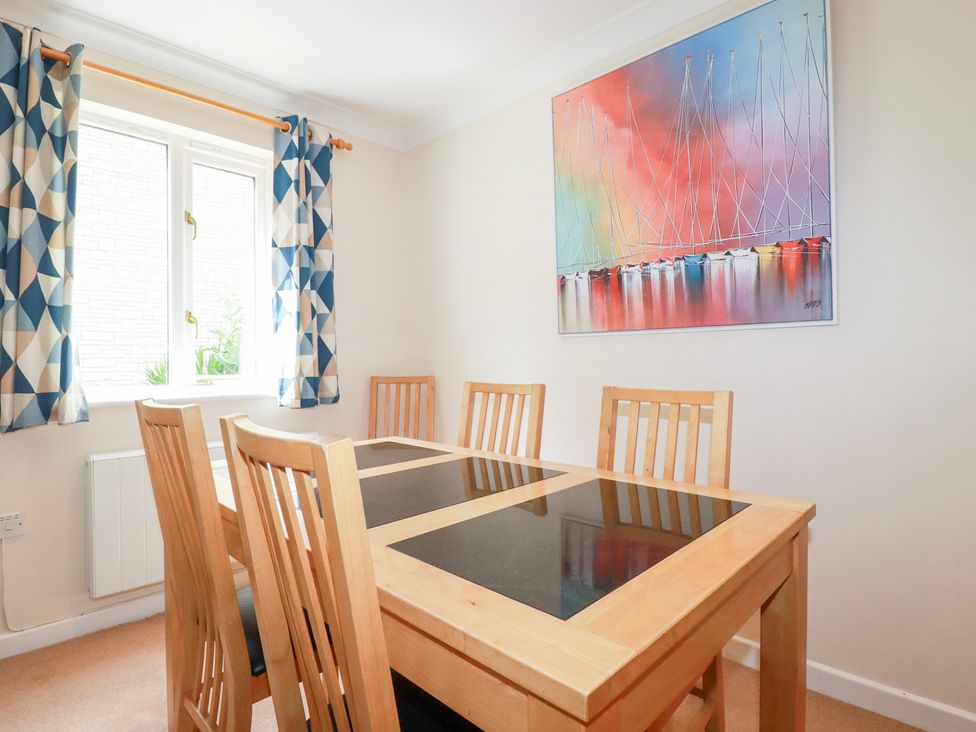 A dining room with a table and chairs at Trouts Reach in Falmouth