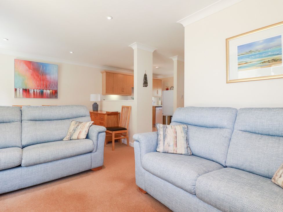 A living room with sofas and a dining area at Trouts Reach in Falmouth