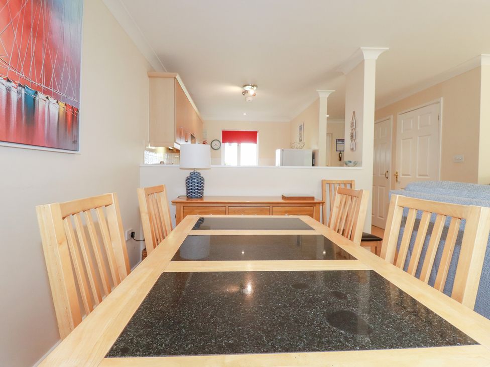 A dining room with a dining table and chairs at Trouts Reach in Falmouth