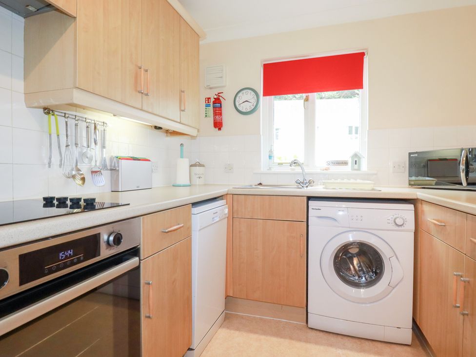 A kitchen with oven, washing machine, and sink at Trouts Reach Falmouth