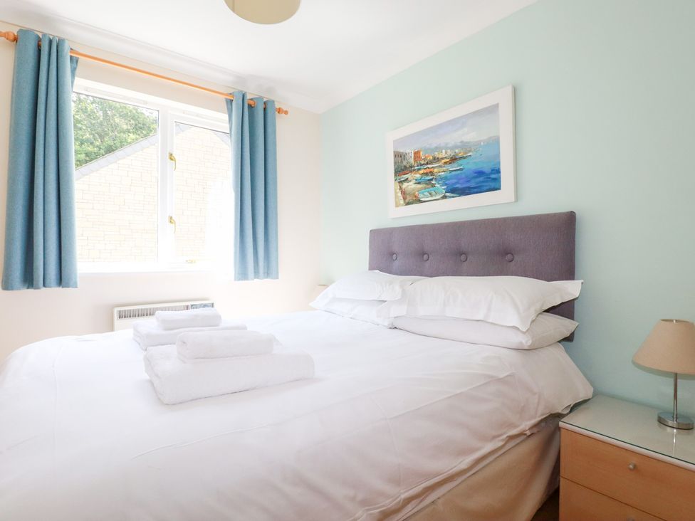 A bedroom with a bed and bedside table at Trouts Reach in Falmouth