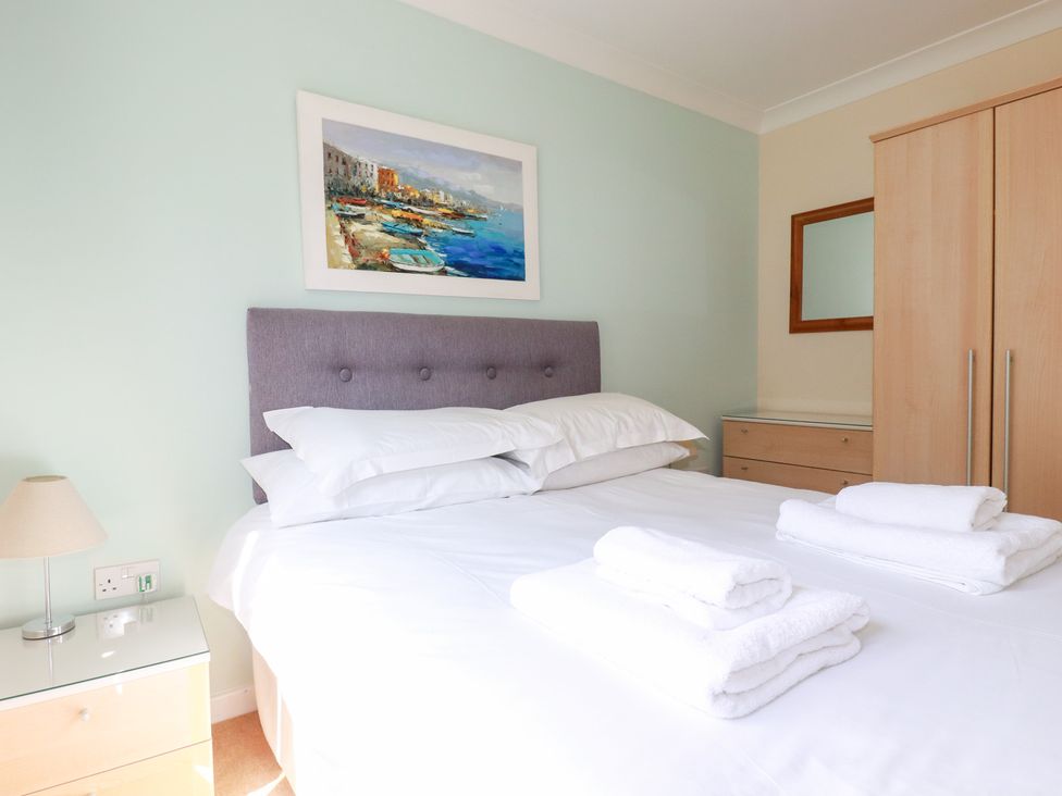 A bedroom with a bed and bedside table at Trouts Reach in Falmouth