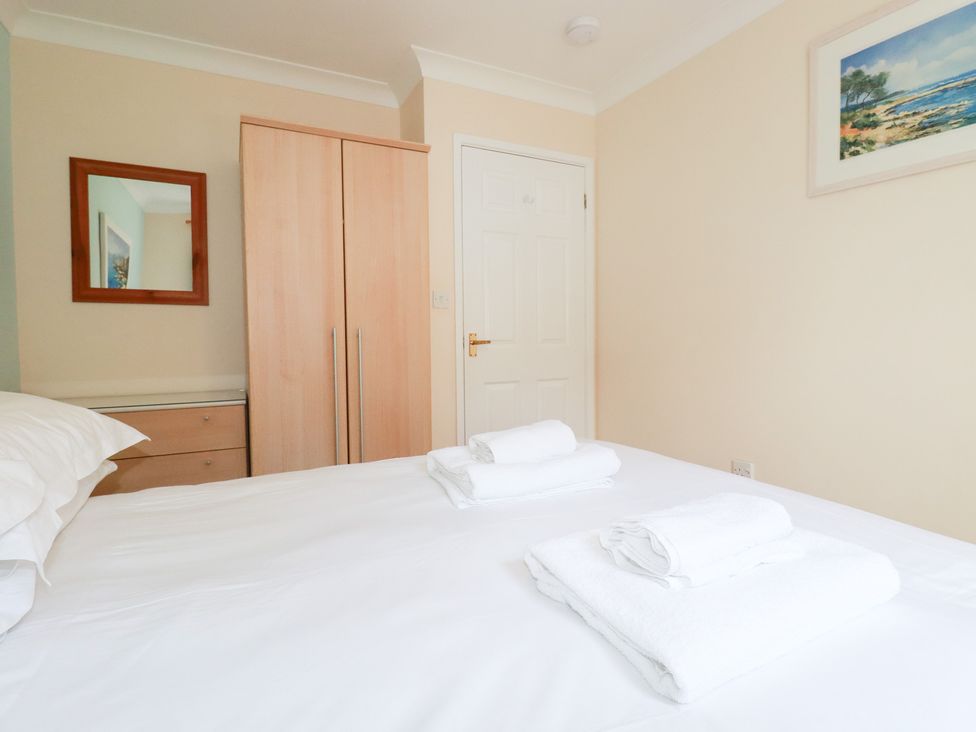 A bedroom with a bed and wardrobe at Trouts Reach in Falmouth