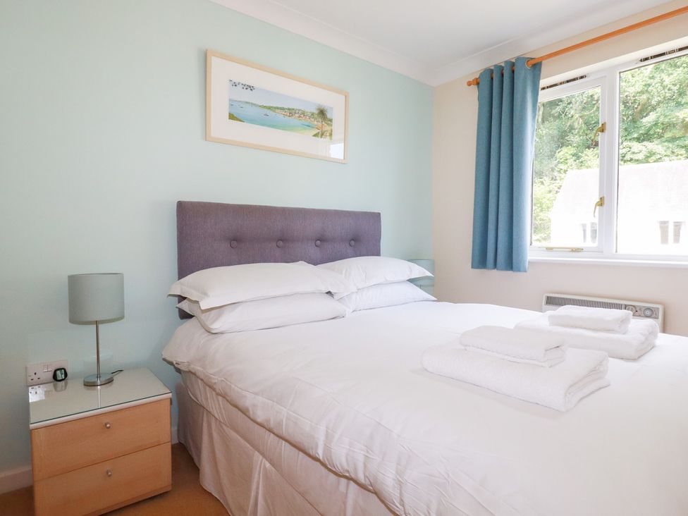 A bedroom with a bed and bedside table at Trouts Reach in Falmouth