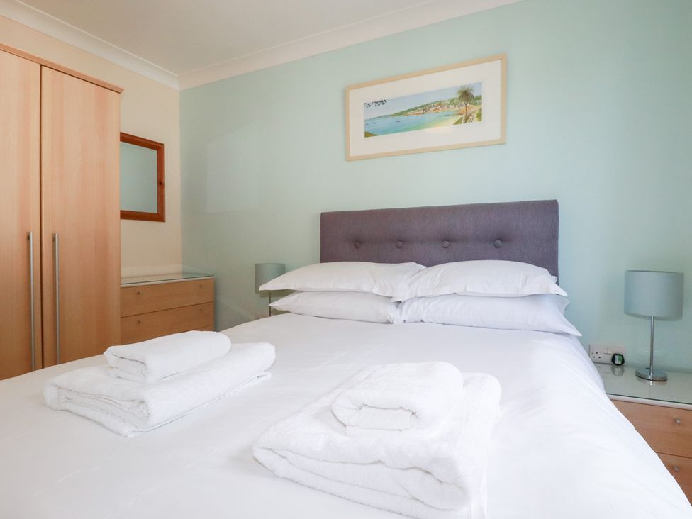 A bedroom with a bed and dresser at Trouts Reach in Falmouth