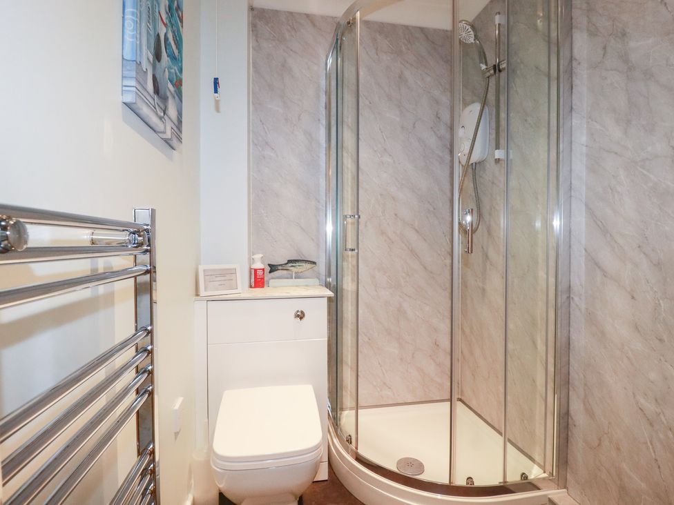 A bathroom with a shower, toilet and sink at Trouts Reach in Falmouth