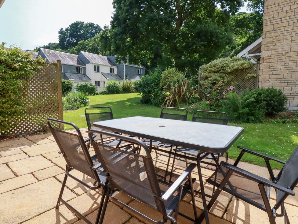 A garden with a table and chairs at Trouts Reach in Falmouth