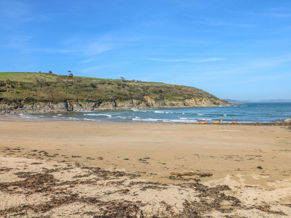 A beach with waves and a cliff at Trouts Reach in Goldenbank near Budock Water