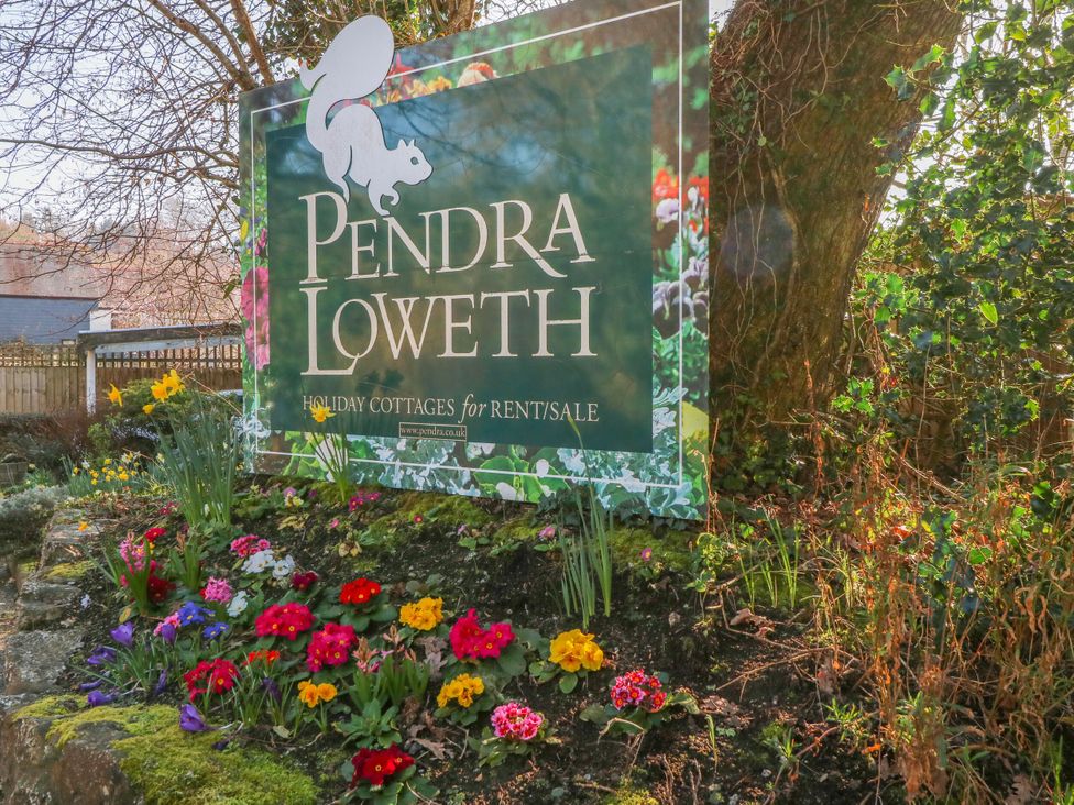 A sign for Pendra Loweth with flowers at Pendra Loweth in Goldenbank near Budock Water
