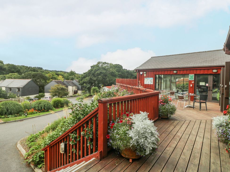 An outdoor seating area with tables and flowers at Trouts Reach Goldenbank near Budock Water