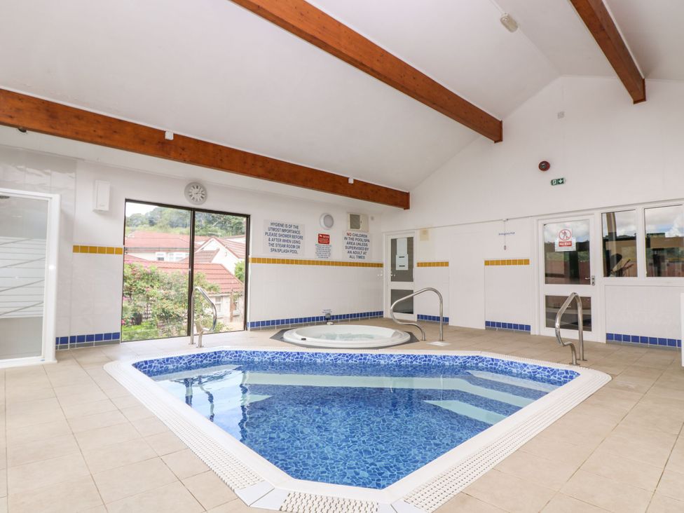 An indoor pool area with a swimming pool and hot tub at Trouts Reach in Goldenbank near Budock Water
