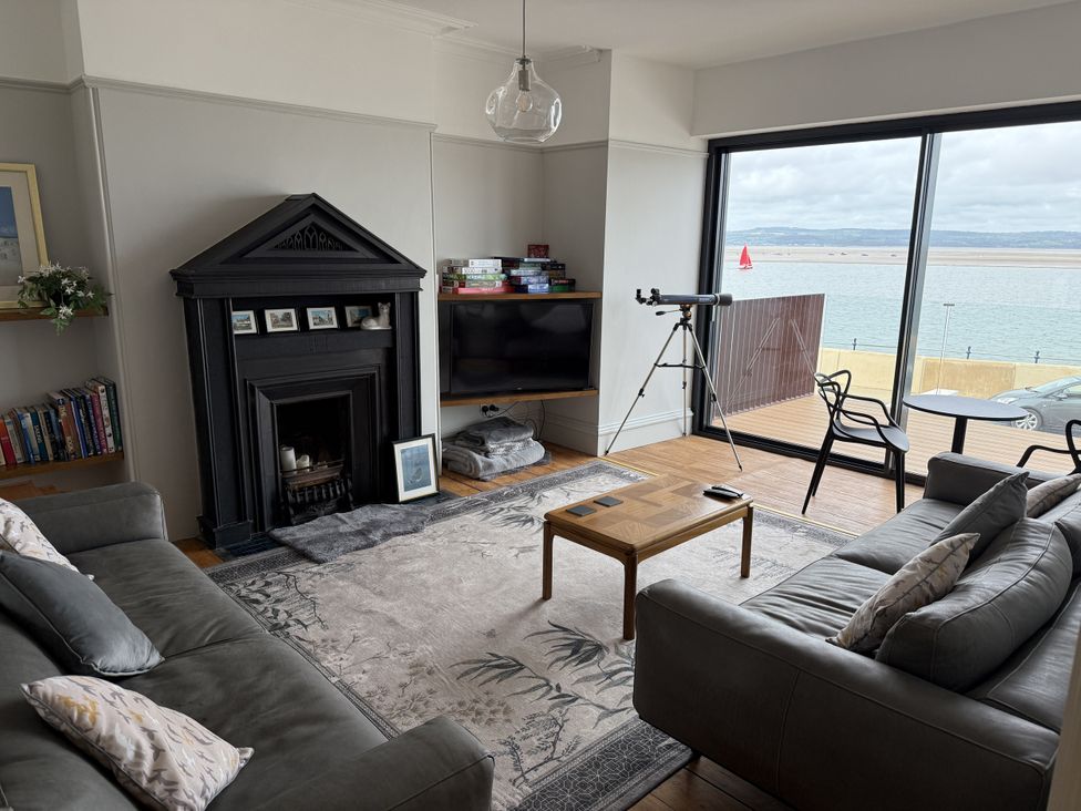 A living room with a fireplace and telescope at Mostyn View in West Kirby