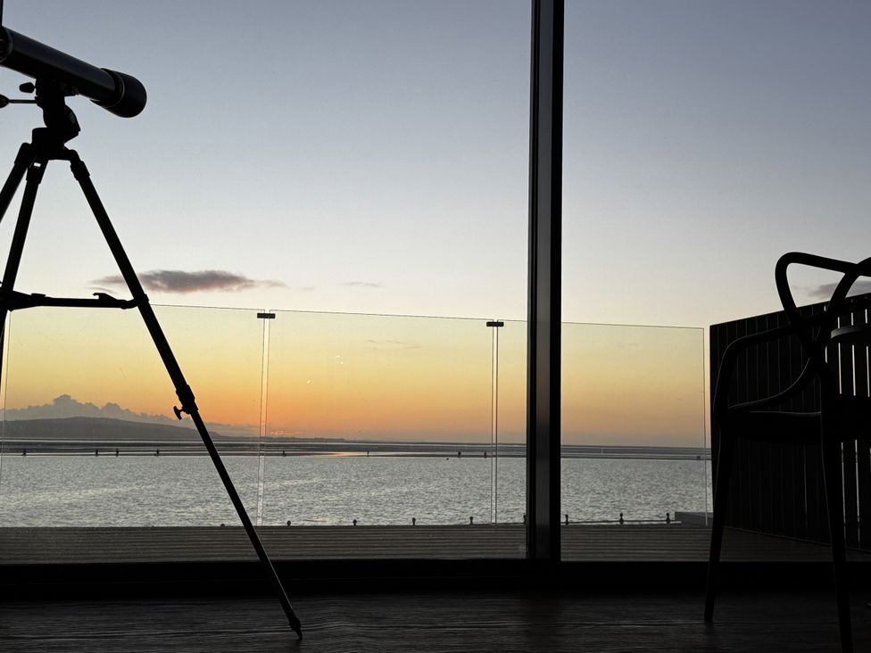 A telescope and chair overlooking water at Mostyn View in West Kirby