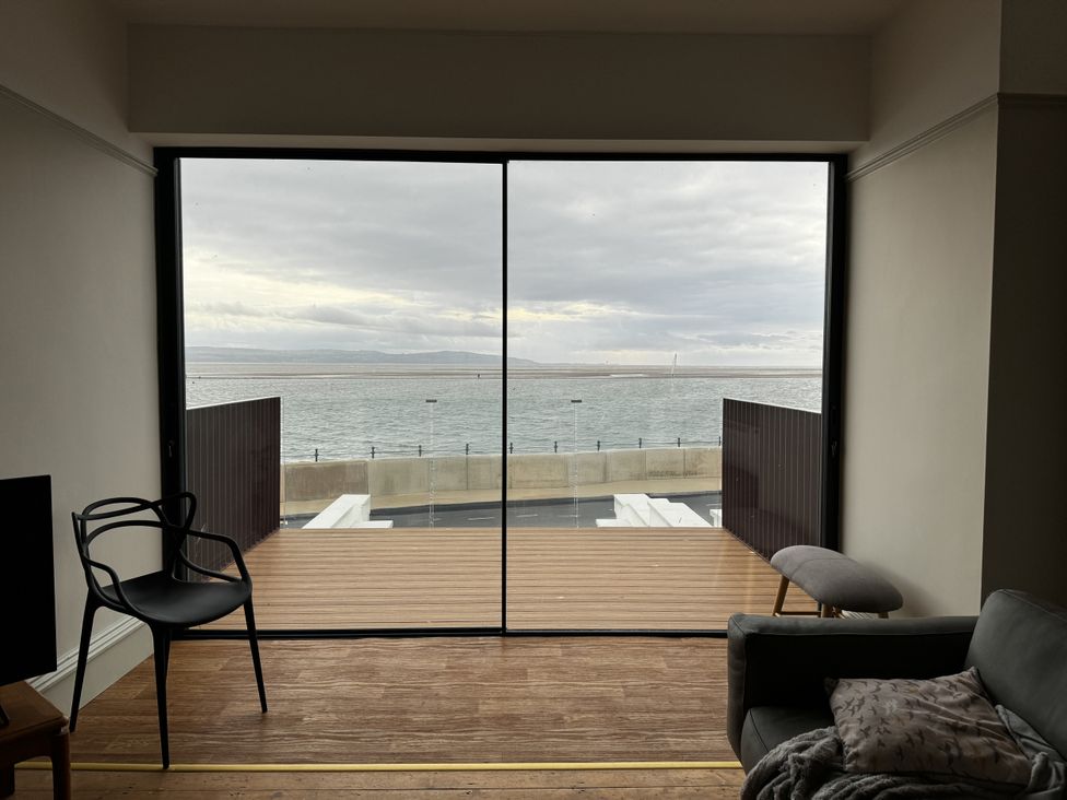 A living room with a view of the sea at Mostyn View in West Kirby