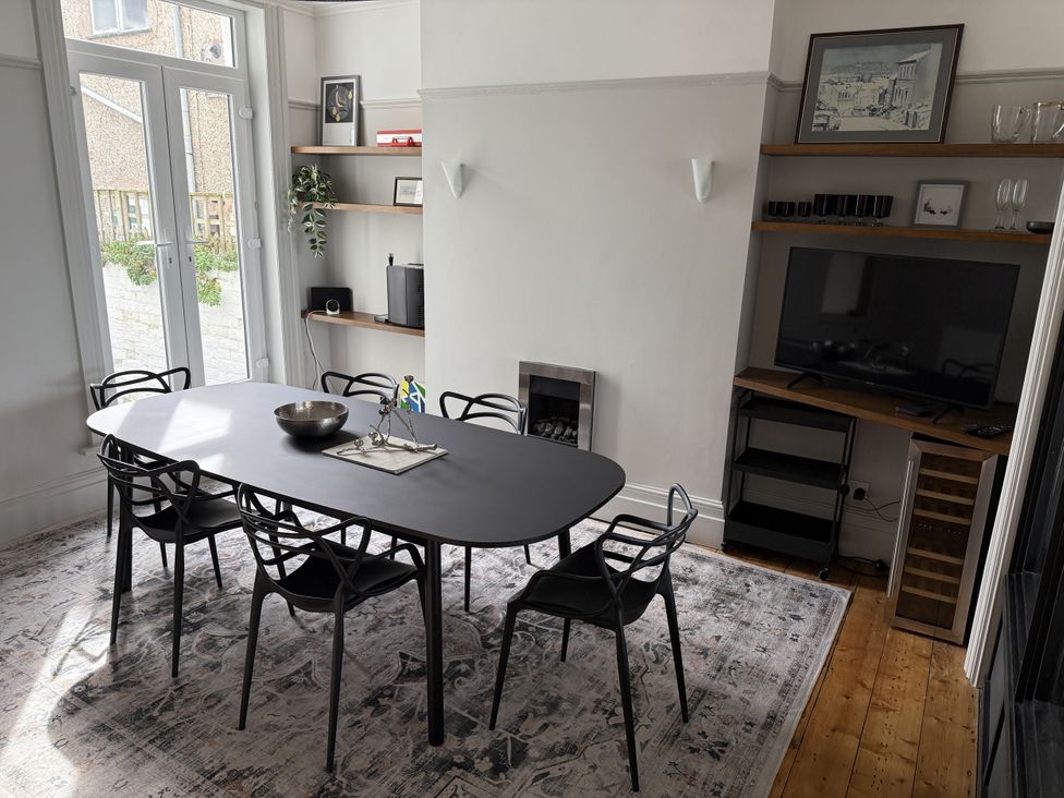 A dining room with a table and chairs at Mostyn View in West Kirby
