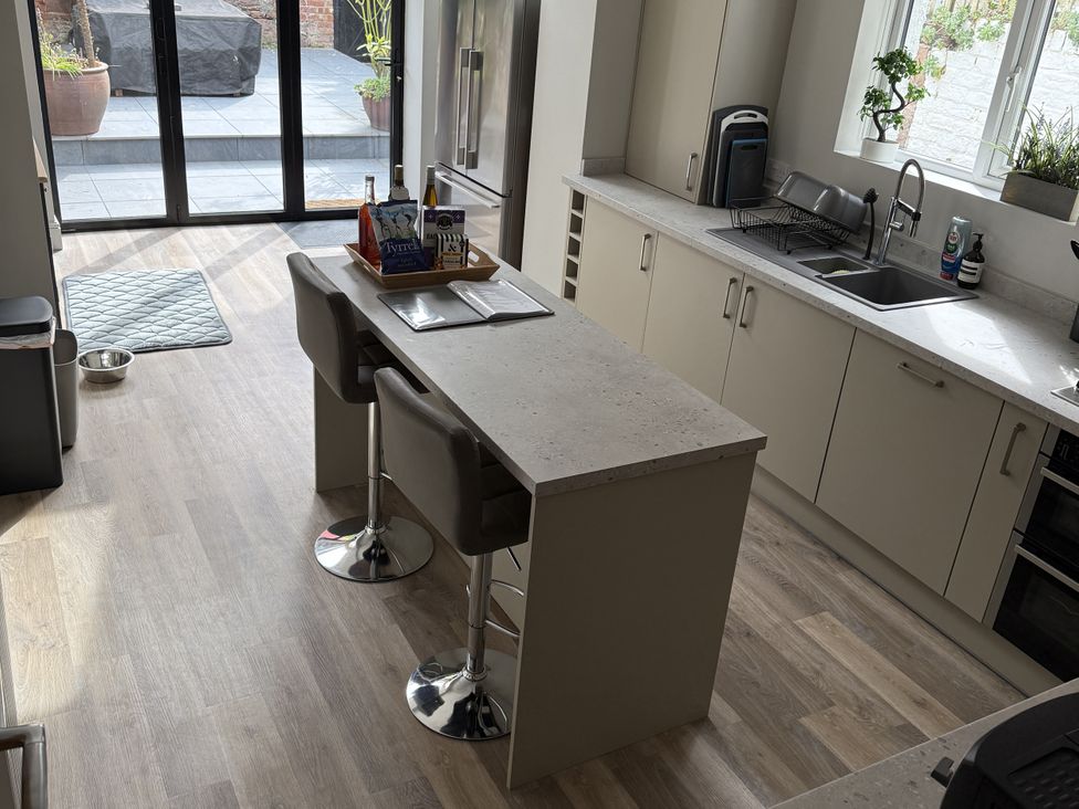 A kitchen with a countertop and bar stools at Mostyn View in West Kirby