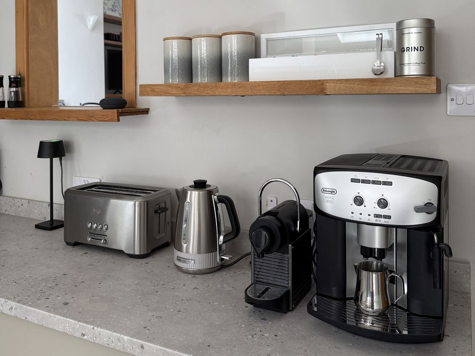 A kitchen countertop with a toaster, kettle, coffee machine, and storage jars at Mostyn View West Kirby