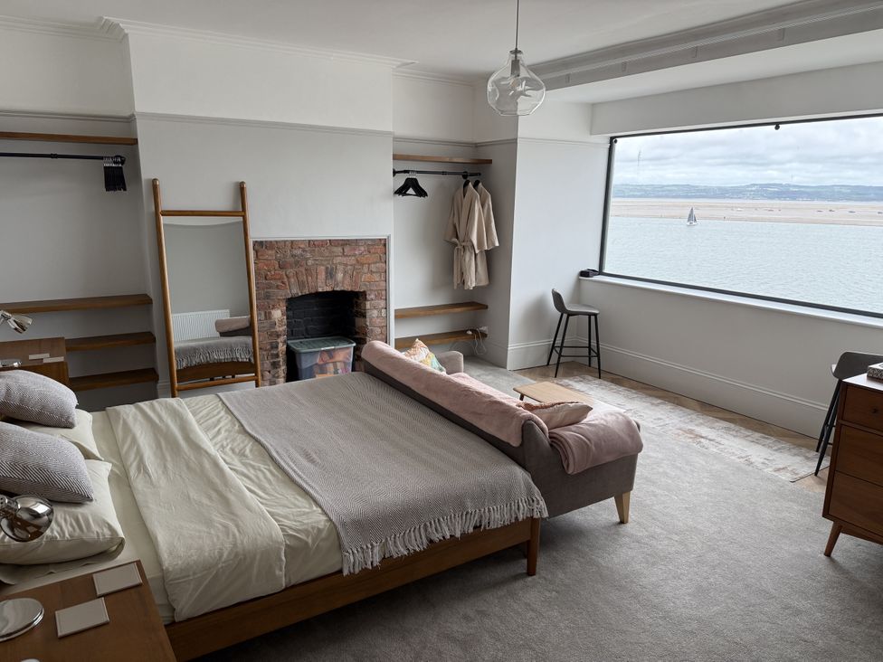 A bedroom with a bed and view of the water at Mostyn View in West Kirby